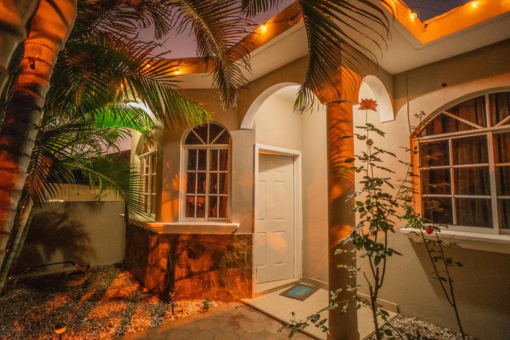 a house with a palm tree and a white door at Cozy Renting Hospedaje in Santa Rosa de Copán