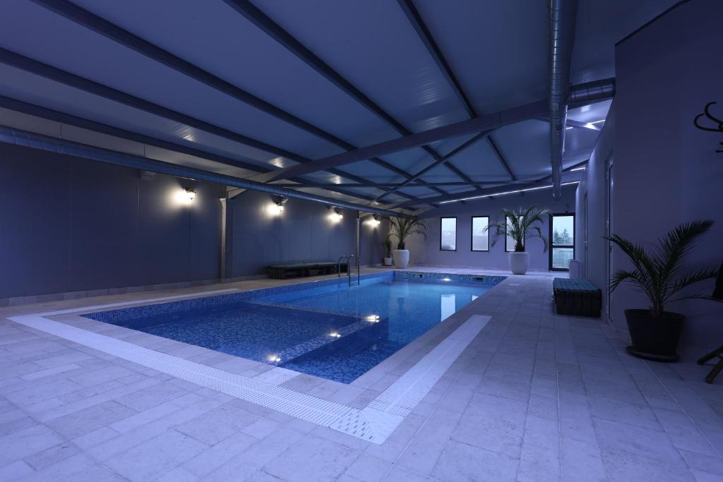 a swimming pool in a building with a blue ceiling at Guest House KOLESHEVI in Byal Izvor