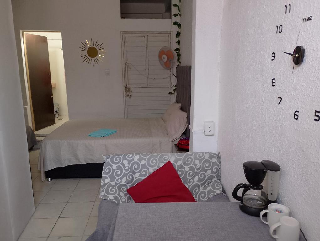 een kleine kamer met een bed en een bank bij Hab privada entrada independiente in Tuxtla Gutiérrez