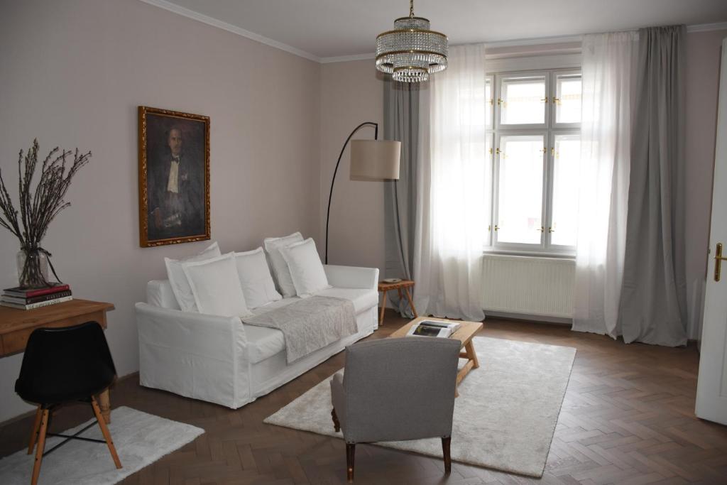 a living room with a white couch and a chair at Center Marvel in Ljubljana