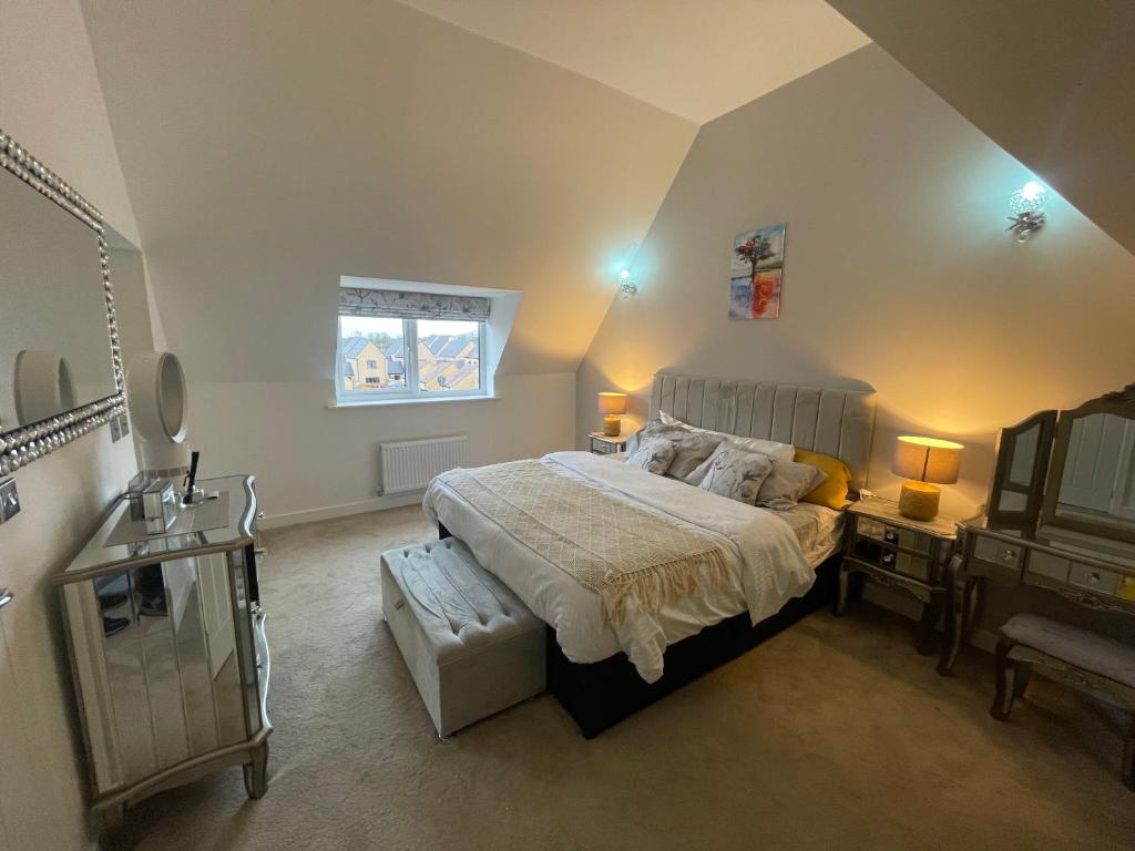 Luxurious Five-Bedroom Haven في Long Stanton: غرفة نوم بسرير كبير ونافذة