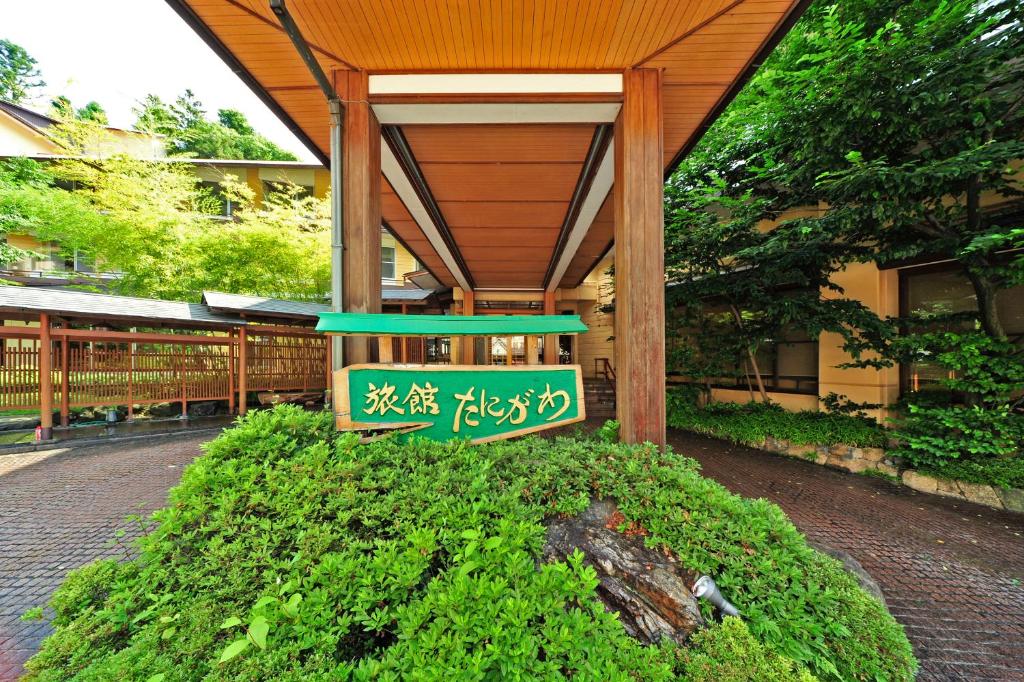 een gebouw met een groen bord ervoor bij Ryokan Tanigawa in Minakami