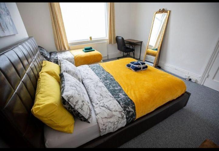 a bedroom with a bed with a yellow blanket and a mirror at Northumberland Cozy Palace B in Old Walker