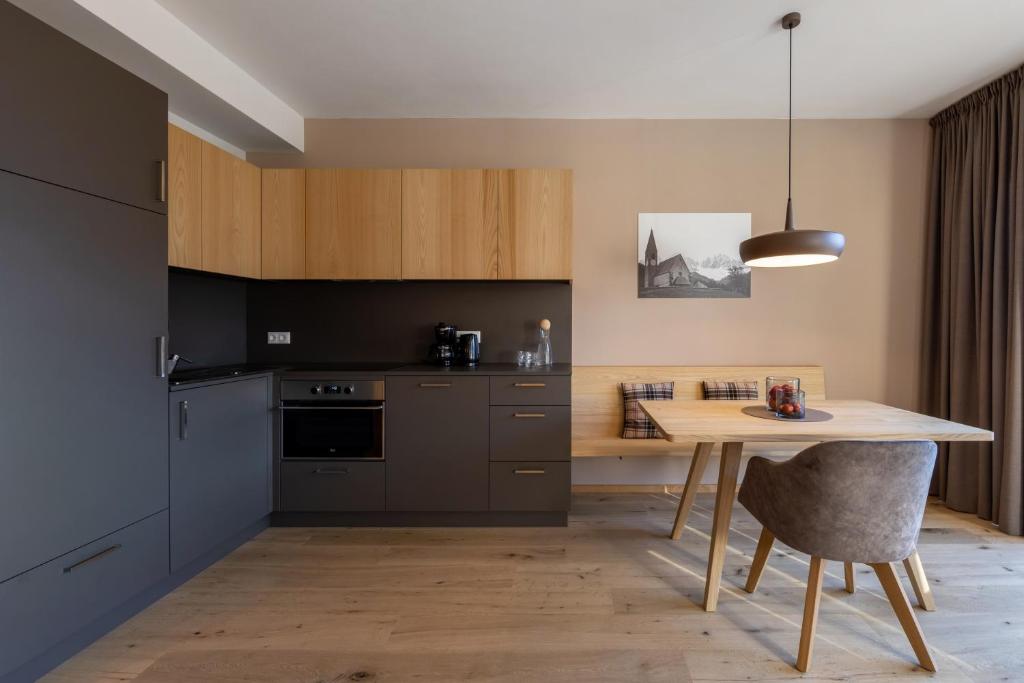 a kitchen with a wooden table and a dining room at Charming Suite by Dornsberg Panoramic Apartments in Schenna