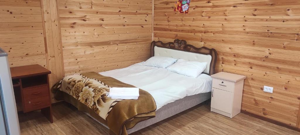 - une chambre avec un lit et un mur en bois dans l'établissement NAREK B&B, à Goris