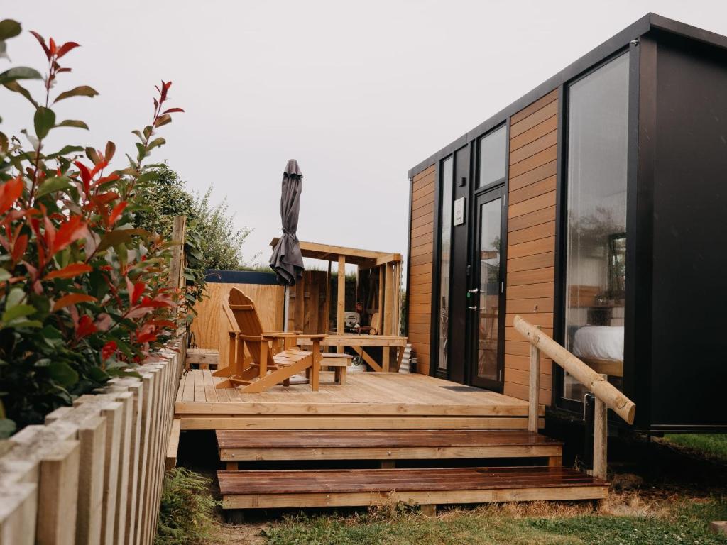 a small house with a wooden deck with a table at Grassmere Orchard in Napier