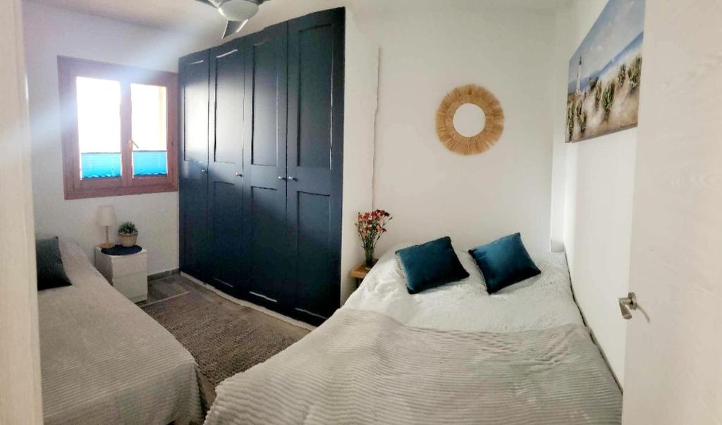 1 dormitorio con 2 camas y puerta azul en Apartamento Luna Blanca, La Mata, 300 m from the sea and sandy beach plus swimming pool, en La Mata