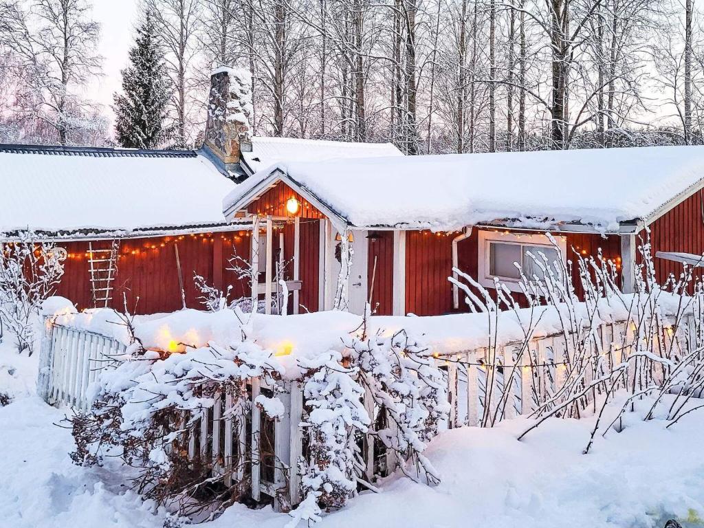 uma cabana vermelha na neve com luzes em Holiday home SÖDERALA em Söderala