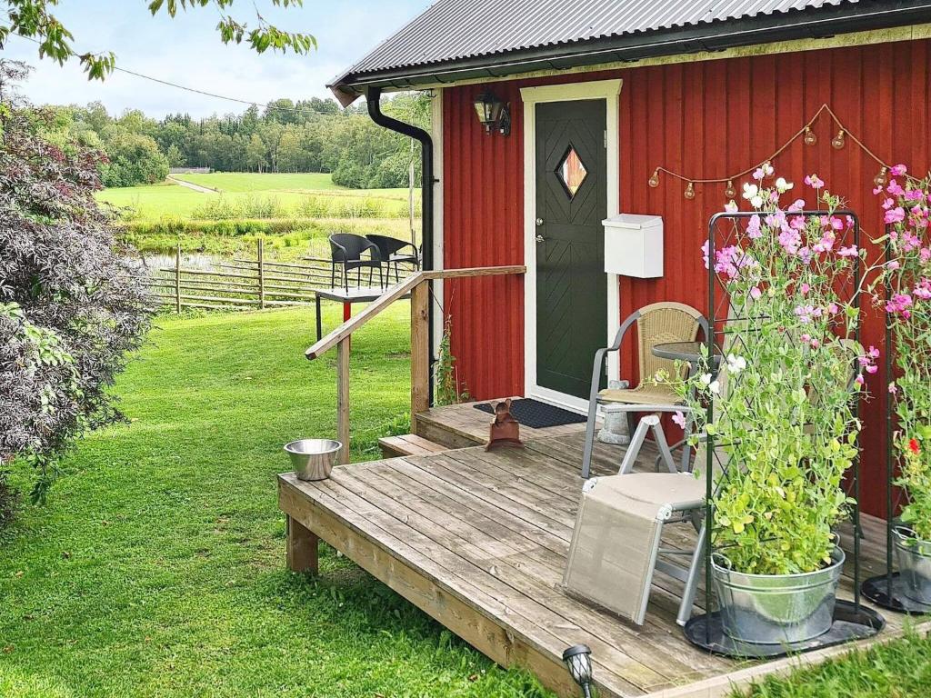 Casa roja con terraza de madera con puerta en Holiday home HALMSTAD X, en Halmstad