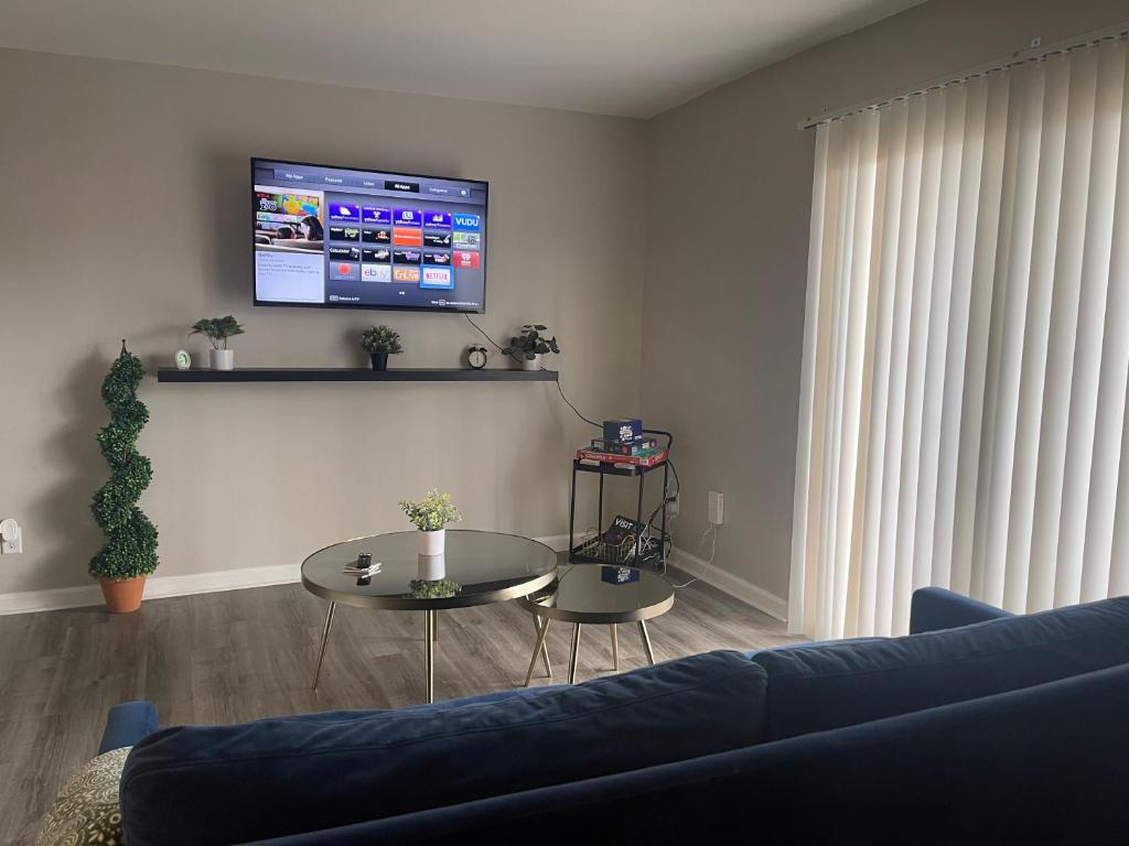 a living room with a couch and a table and a tv at Cute & Cozy Suite in Overland Park in Overland Park