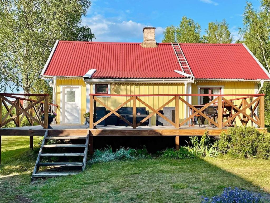 une petite maison jaune avec un toit rouge dans l'établissement Holiday home HÖGSBY II, à Högsby