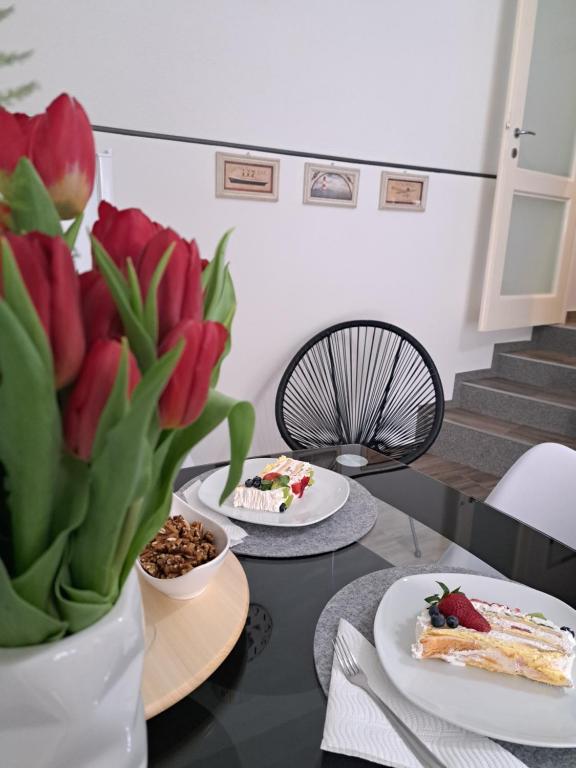 deux assiettes de nourriture sur une table avec des fleurs dans l'établissement Kuća za odmor Eni ****, à Šibenik