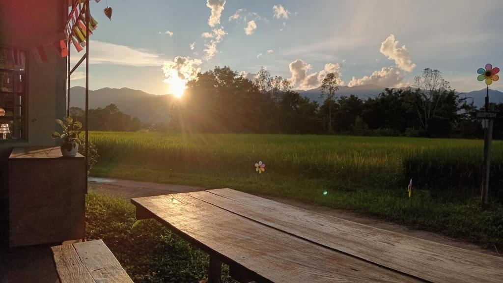 a wooden bench sitting in front of a field at Chill In Pai - ชิลล์ อิน ปาย in Pai