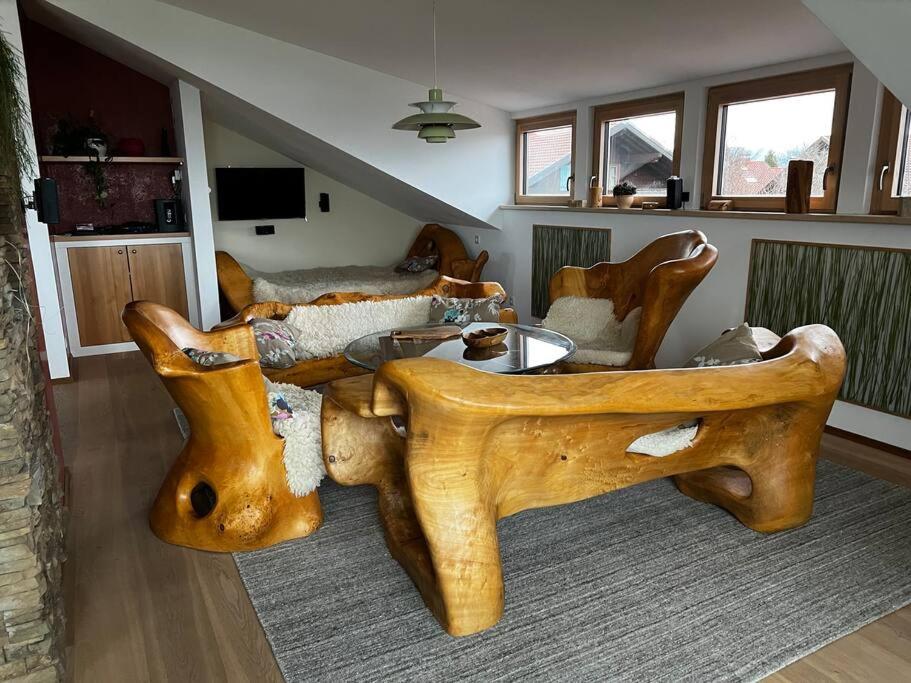 uma sala de estar com uma grande mesa de madeira e sofá em Pit-Stop Allgäu em Argenbühl
