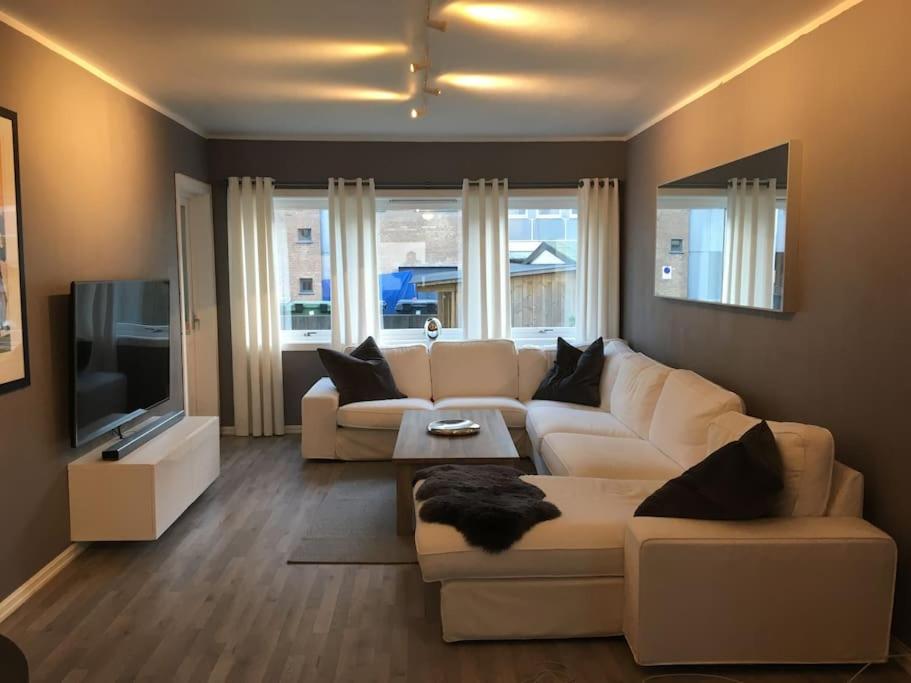 salon z białą kanapą i telewizorem w obiekcie Trivelig leilighet i Kristiansand sentrum! w mieście Kristiansand