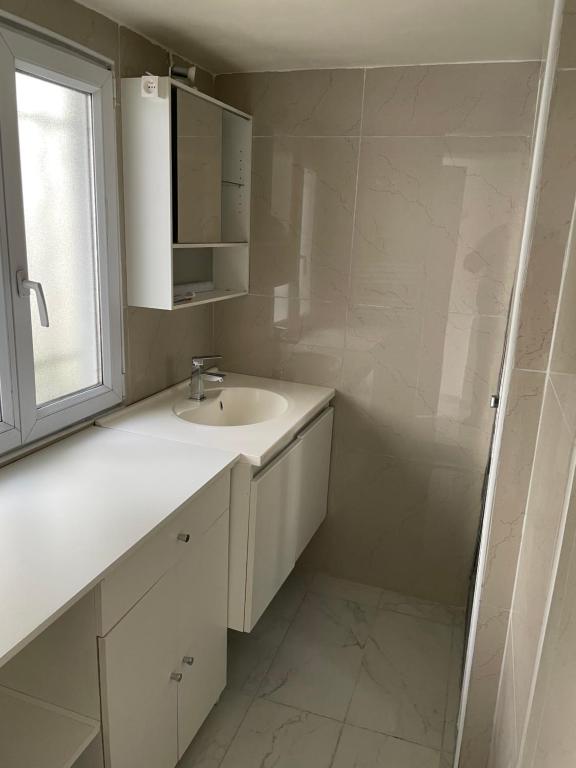 a white bathroom with a sink and a window at Maison indépendante 7 minutes RER B in Antony