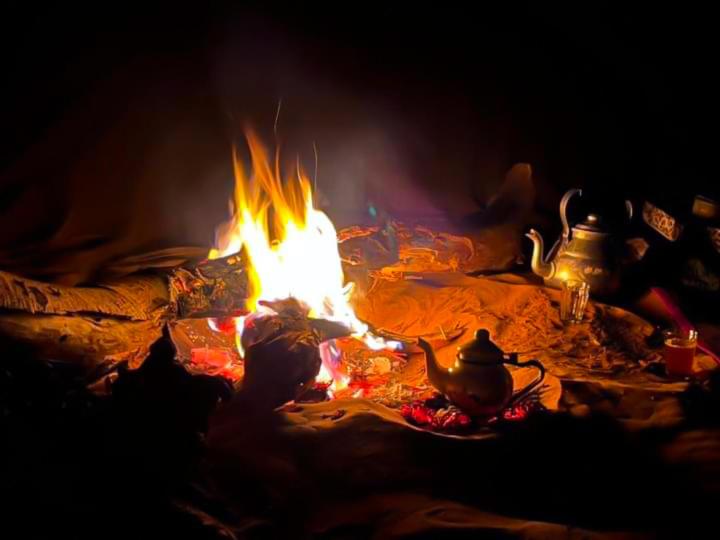 eine Feuerstelle mit einem Wasserkocher und einer Teekanne in der Unterkunft Nomad Life Style in M’hamid El Ghizlane