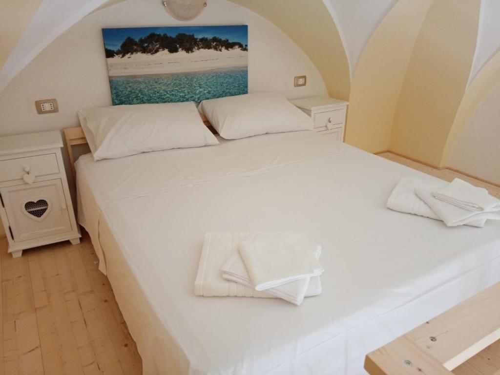 een slaapkamer met 2 bedden en witte lakens bij Salento Rooms in Leverano