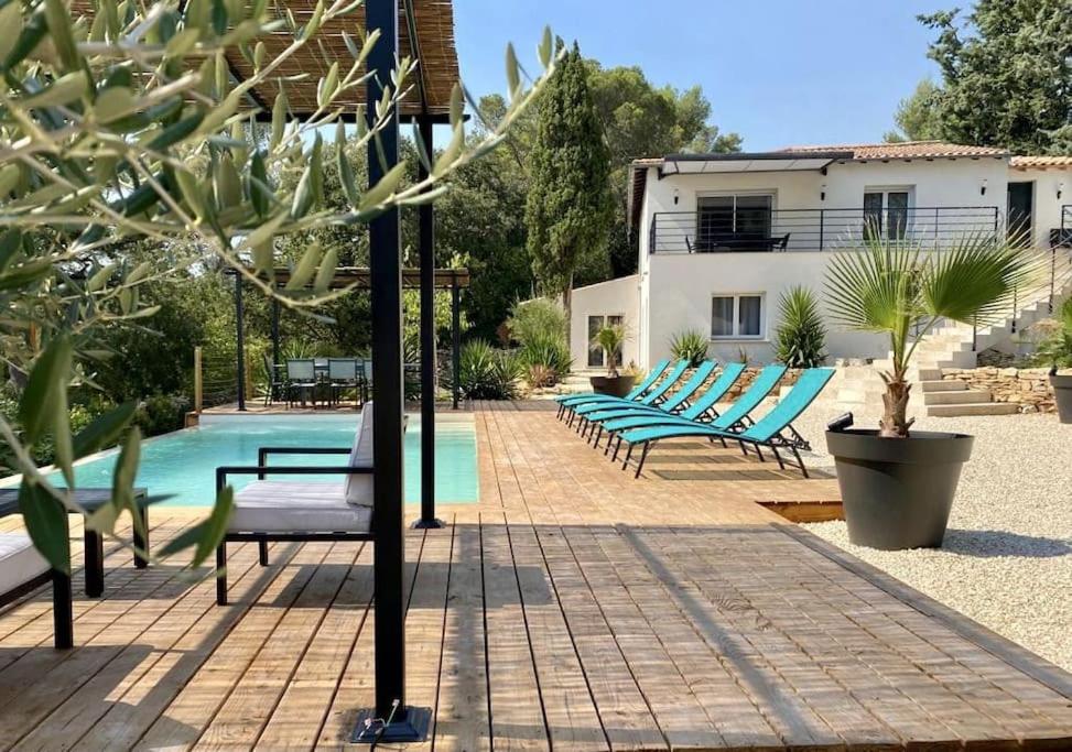une rangée de chaises bleues assises à côté d'une piscine dans l'établissement La villa du soleil, à Nîmes