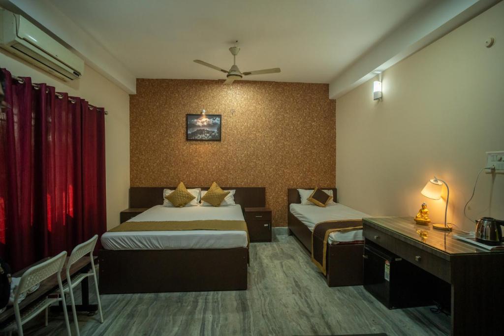 a hotel room with two beds and a desk at Siliguri Club in Siliguri