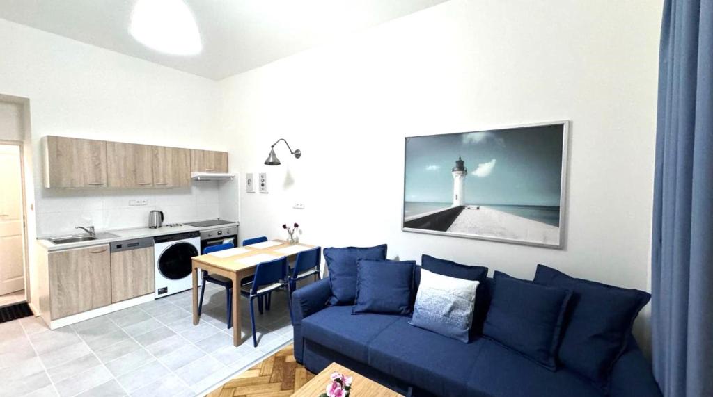 a living room with a blue couch and a kitchen at Side Street Apartments in Prague
