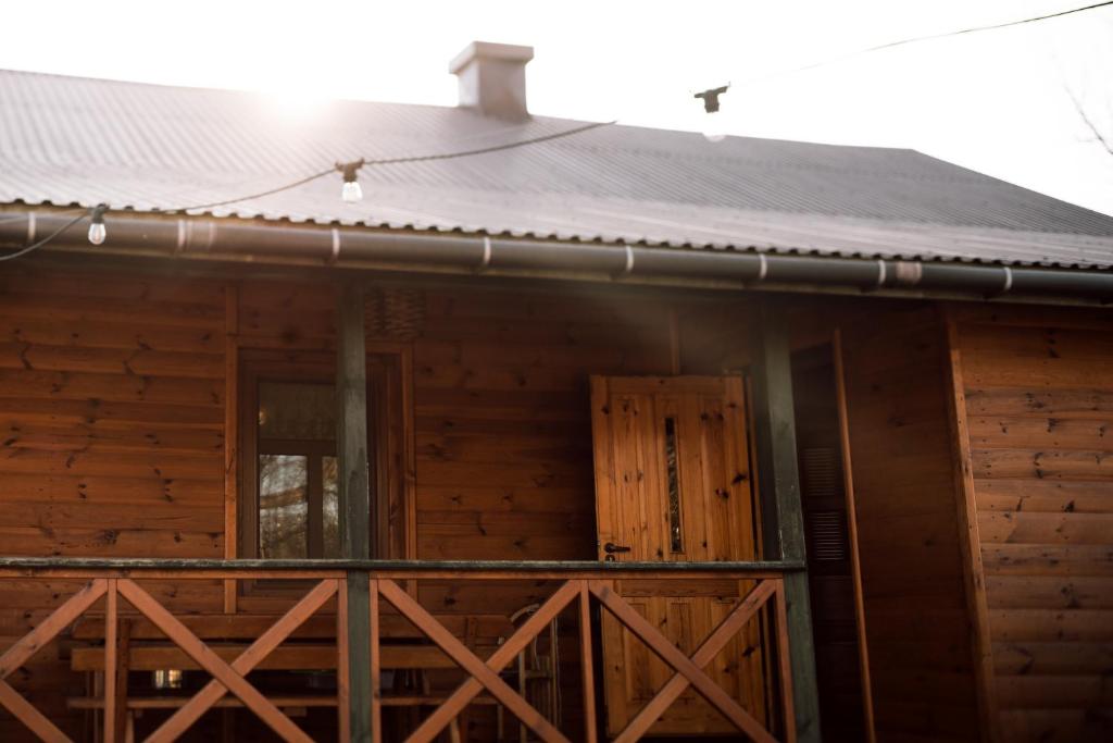 drewniany domek z werandą i drzwiami w obiekcie Agroturystyka Łączka w mieście Harasiuki