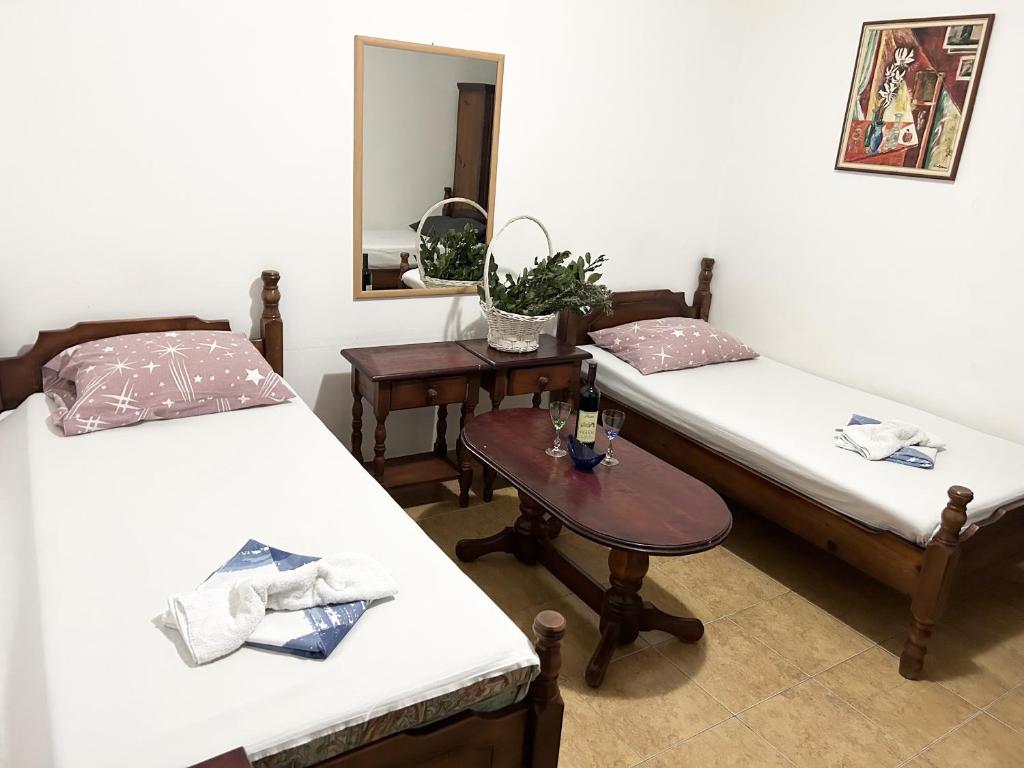 a room with two beds and a table with a mirror at Restaurant & Apartments JUG in Sutomore