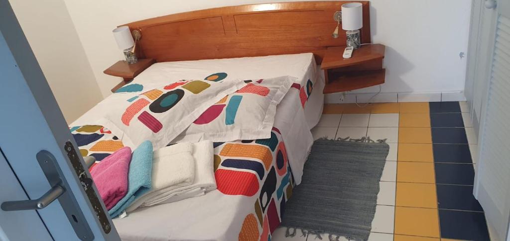 a bedroom with a bed with a comforter and a floor at Folle Anse Paradise in Saint-Louis