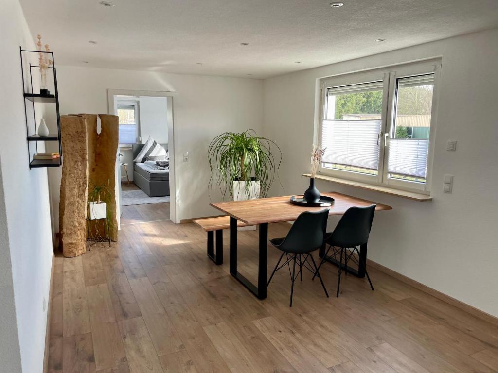 a dining room and living room with a table and chairs at Anitas Ferienwohnung in Meßkirch