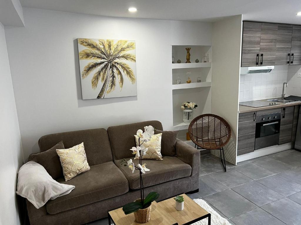ein Wohnzimmer mit einem Sofa und einer Küche in der Unterkunft Appartement en rez-de-jardin in Vitry-sur-Seine
