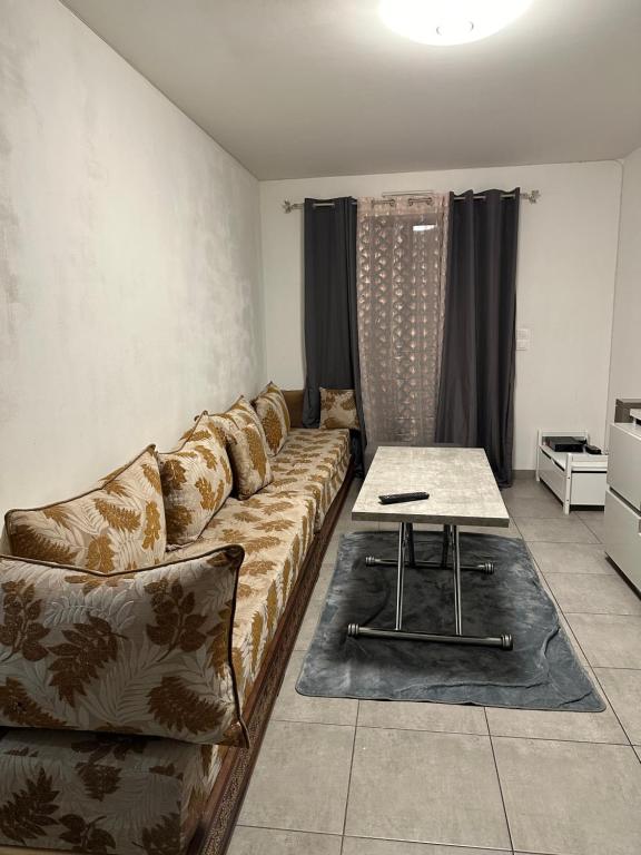 un salon avec un canapé et une table dans l'établissement L'appartement, à Tremblay-en-France