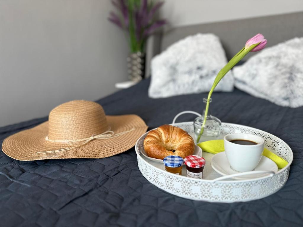 a tray with a hat and a cup of coffee and a plate of food at BaSoTo in Sopot