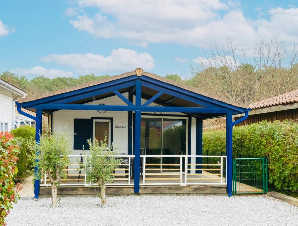 Casa pequeña con porche azul y blanco en Cottage 5 personnes Bias Mimizan, en Bias