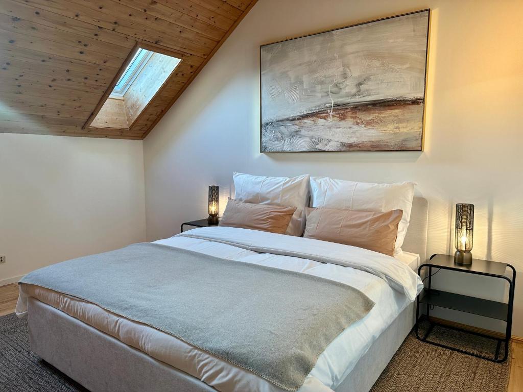 ein Schlafzimmer mit einem großen weißen Bett mit zwei Lampen in der Unterkunft 17er Apartment mit Sauna und privater Garage in Mondsee