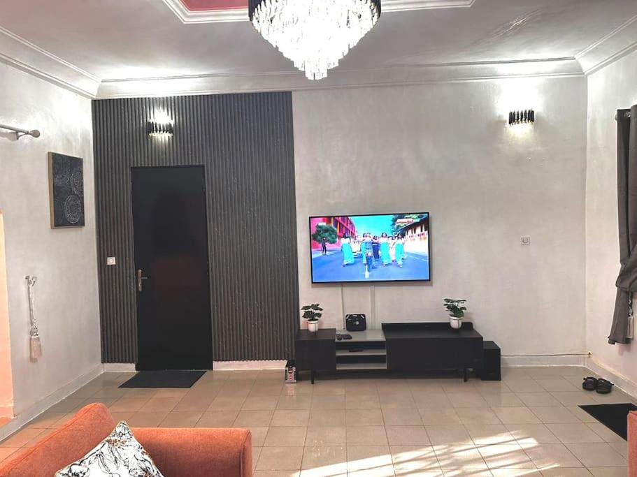 sala de estar con TV de pantalla plana en la pared en Résidence meublée en Uagadugú