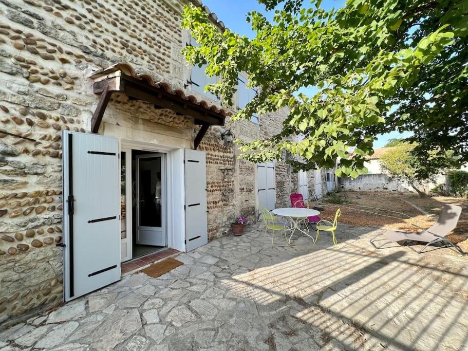 un patio avec une table et un bâtiment dans l'établissement MAS DE LA BOURIDE, à Bellegarde