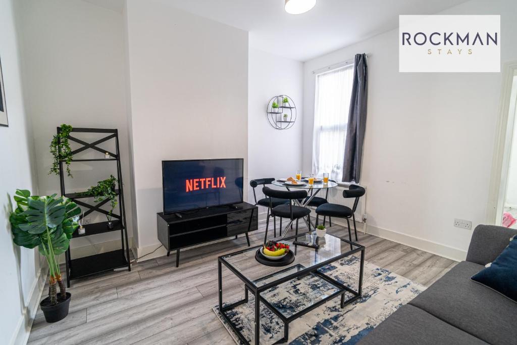 a living room with a couch and a tv at Spacious 7 Bed House with Garden by Rockman Stays in Southend-on-Sea
