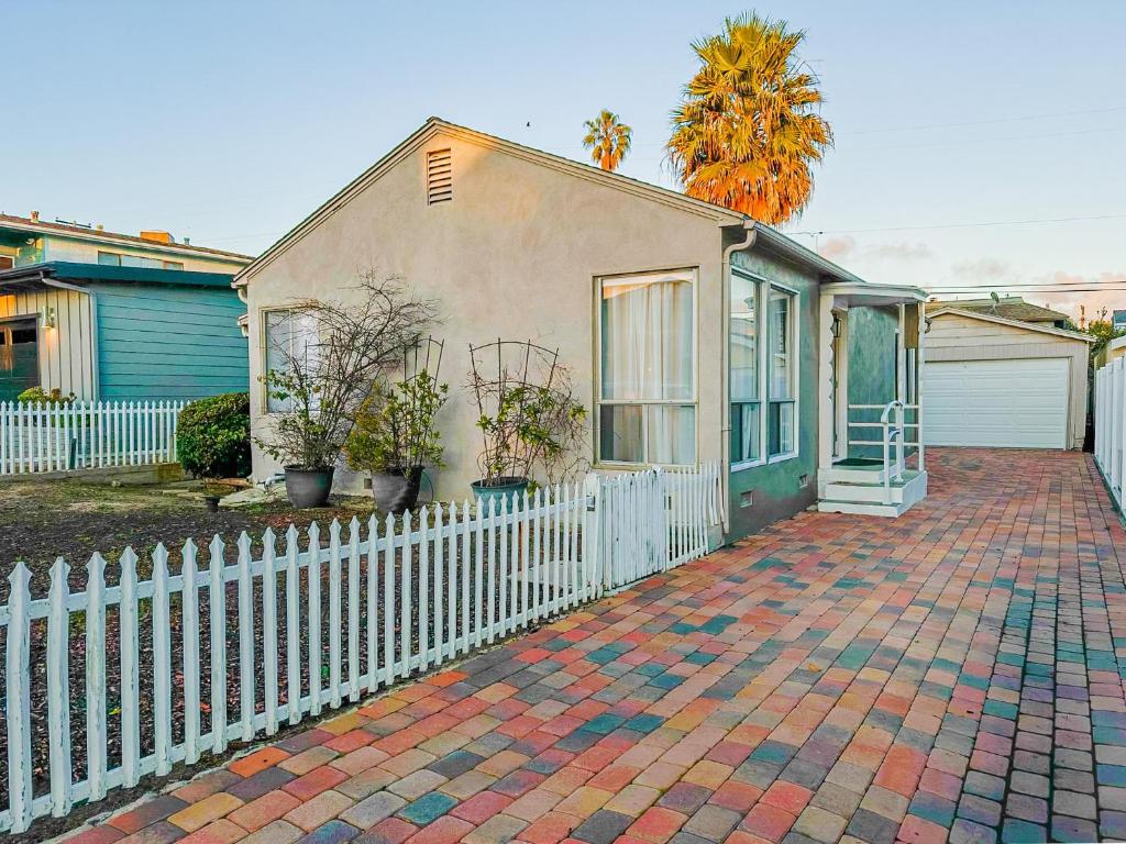 a house with a white fence and a brick driveway at Villa Cardona, Dana Point great location, energy close to the beach/Harbor in Dana Point