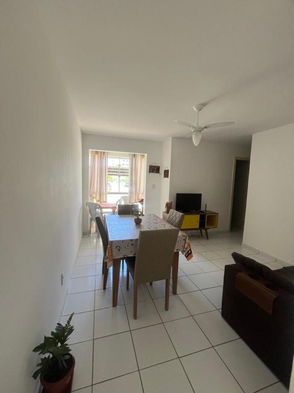 a dining room and living room with a table and chairs at Mar de Aruana - Apartamento Suíte com Ar Aracaju-SE in Aracaju