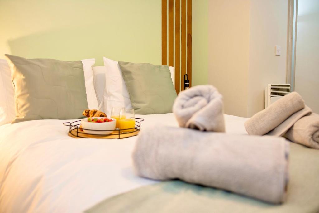 a bed with towels and a tray of food on it at Modern Flat in Sheffield, South Yorkshire in Sheffield