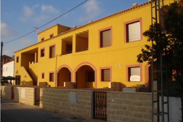 een geel gebouw aan de straatkant bij Apartamentos Turísticos Edificio del Pino in Sorbas