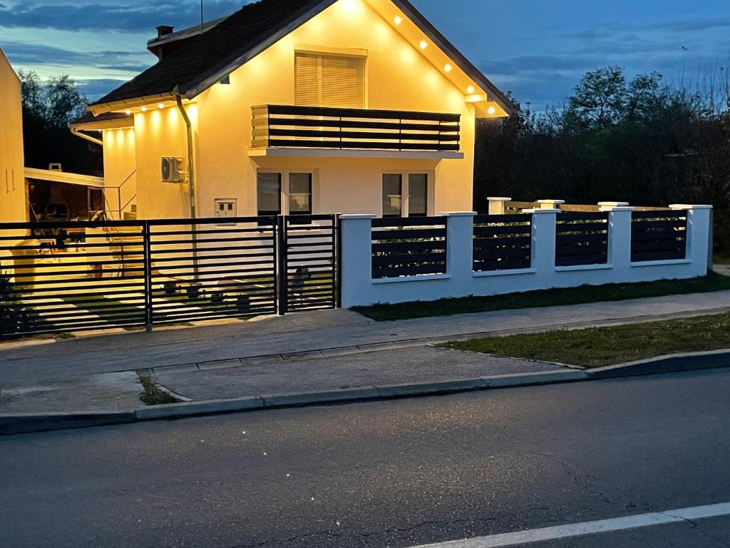a house with a fence in front of it at Kuća za odmor Erdelji in Vardarac