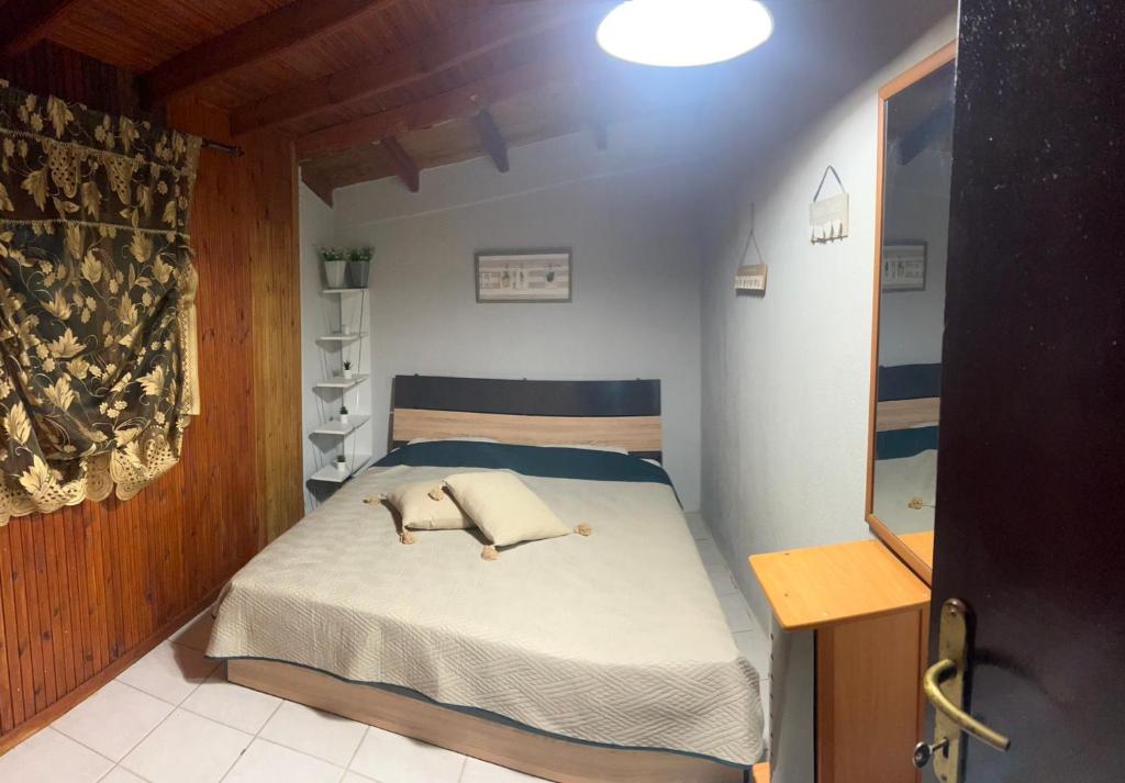 a bedroom with a bed with two pillows on it at SELO APARTMENTS in Nea Kalikratia