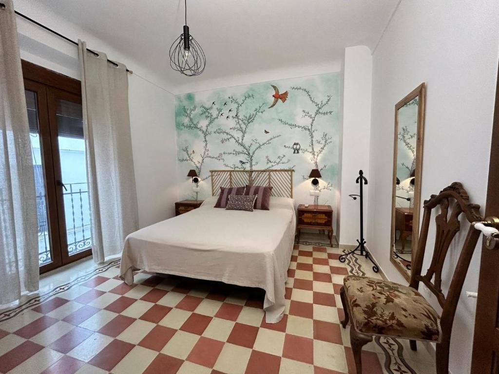 - une chambre avec un lit et un sol en damier dans l'établissement LA BUENA ESTRELLA, à Arbuniel