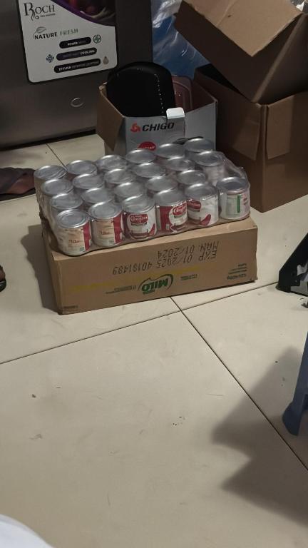 a box of canned food sitting on the floor at Gee guest house in Accra