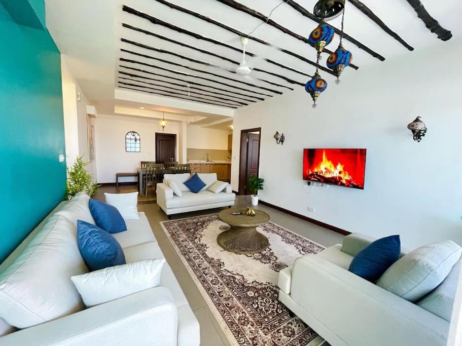 a living room with white couches and a fireplace at Stunning 2 Bed Room Unit with Ocean View in Mariakani