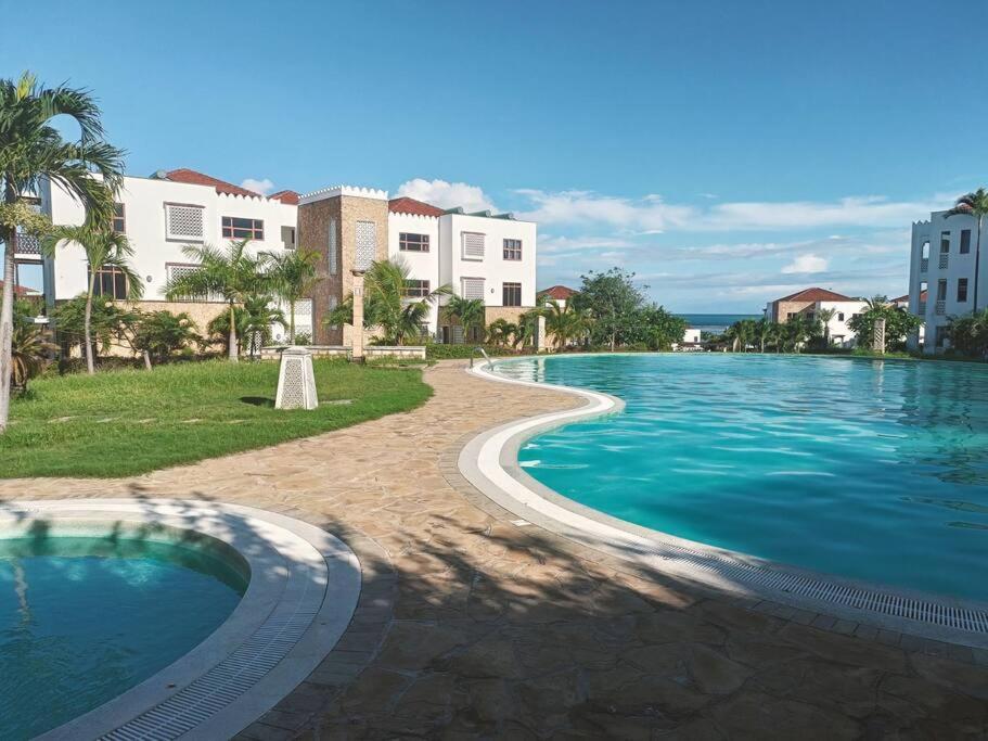 MariakaniStunning 2 Bed Room Unit with Ocean View的度假村内有建筑物的大型游泳池
