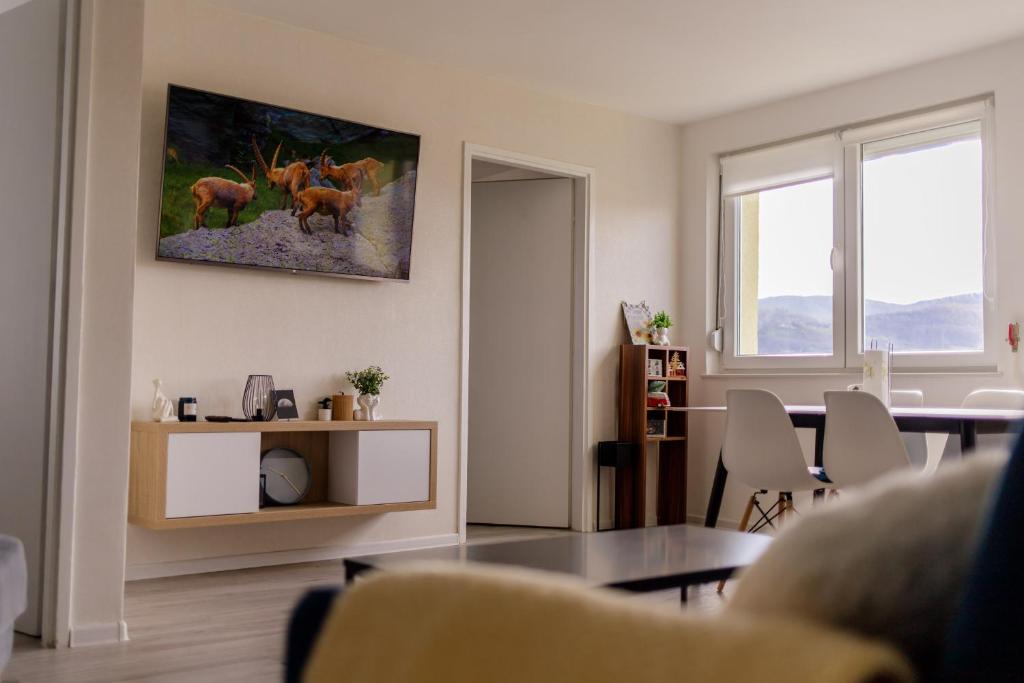 ein Wohnzimmer mit einem Tisch und einem Gemälde von Hirschen an der Wand in der Unterkunft 5 min Apartment in Banja Luka