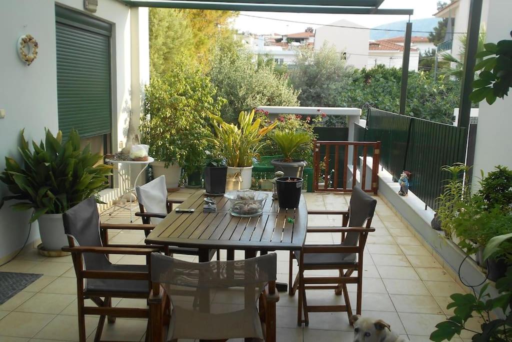 - une terrasse avec une table, des chaises et un chien dans l'établissement Pela's studio 6 minutes from the Athens airport, à Leondárion