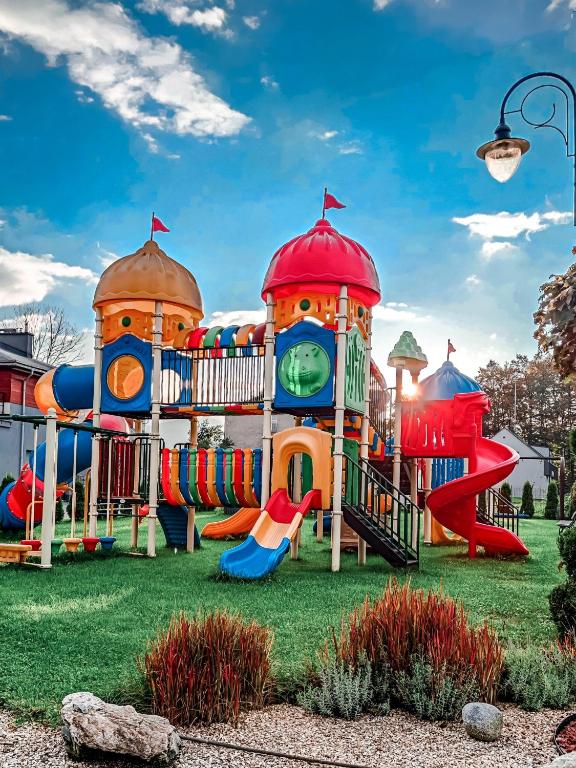 a playground in a park with a clock tower at Apartamenty koło Szczyrku A&S Spa - basen, jacuzzi, sauna in Szczyrk